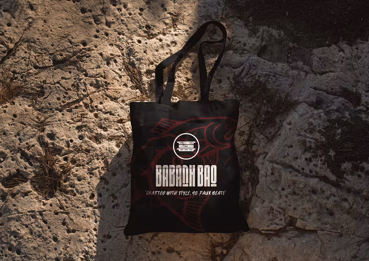 Babanh Bao black tote bag with logo photographed on textured stone surface.
