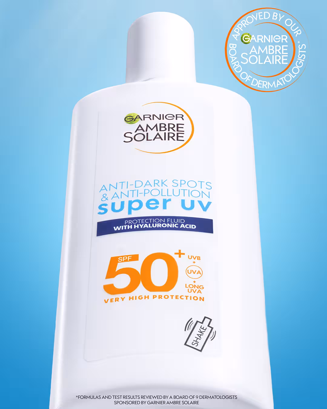 Close-up of Garnier Ambre Solaire Super UV SPF 50+ sunscreen packaging against bright blue background.