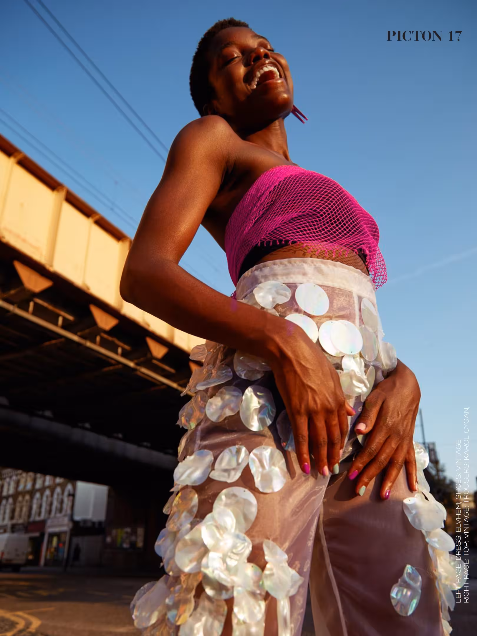 Full-body shot of Abigail Whitney posing outdoors in a magenta top and layered white disco trousers, featured in Picton Magazine Heatwave editorial.