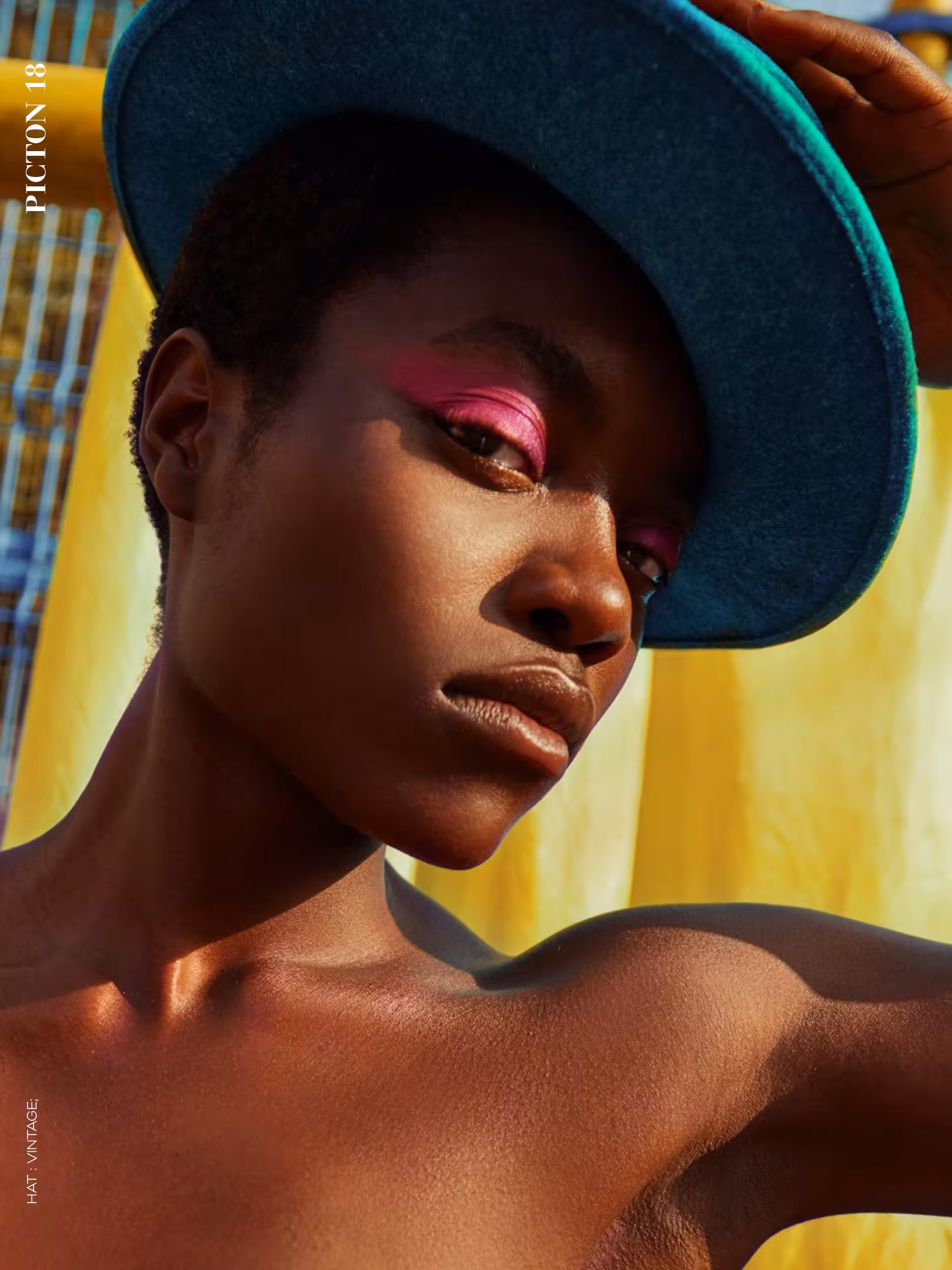 Close-up portrait of Abigail Whitney wearing a wide-brimmed teal hat and bold pink eyeshadow, Picton Magazine editorial.