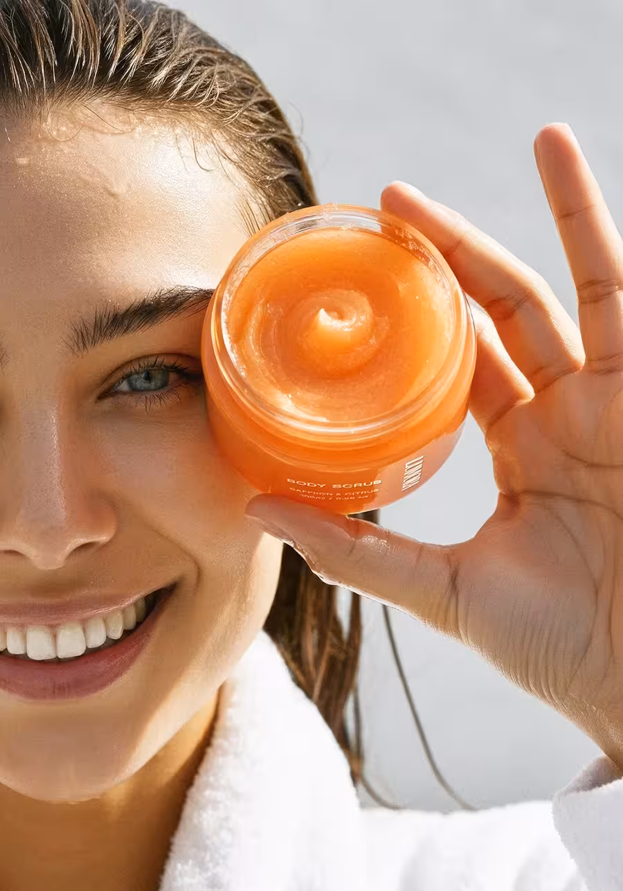Lumora branding paired with a smiling model holding body scrub product.