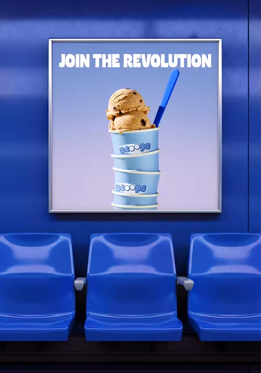 Cup of ice cream with two scoops, placed in front of three blue subway chairs, with the text “Join the Revolution” on a blue wall.
