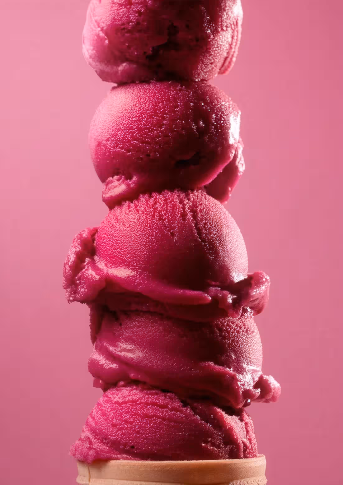 Tower of bright pink ice cream scoops stacked vertically.